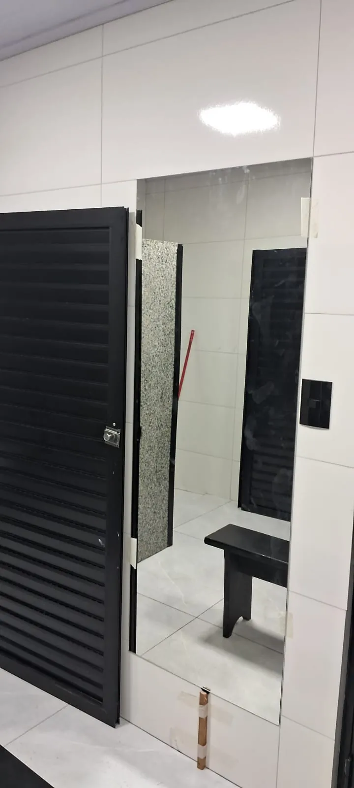 Espelho instalado em ambiente com porta veneziana
