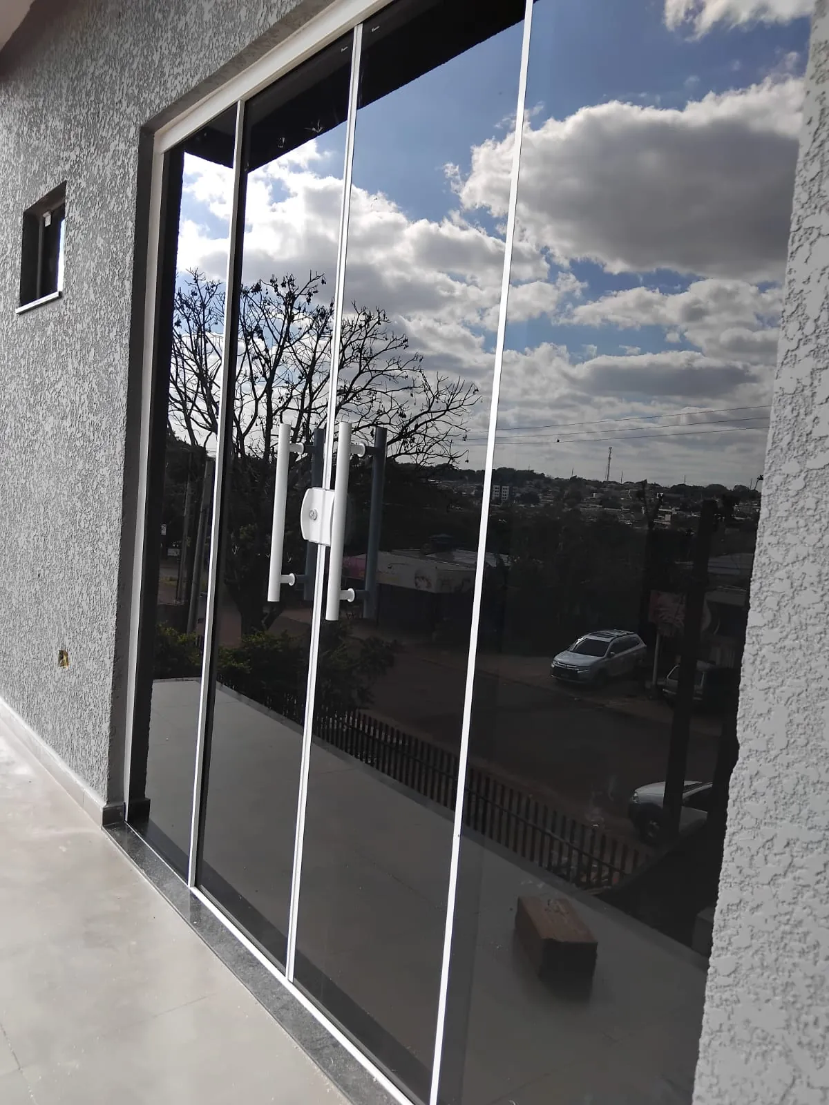 Porta de correr em vidro temperado com perfis pretos, instalada pela R&A Vidraçaria em Cascavel